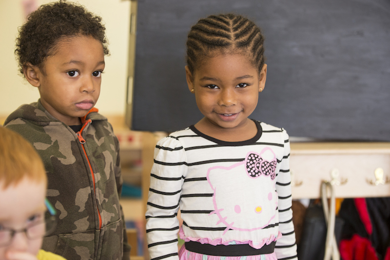 A young girl smiles in a classroom