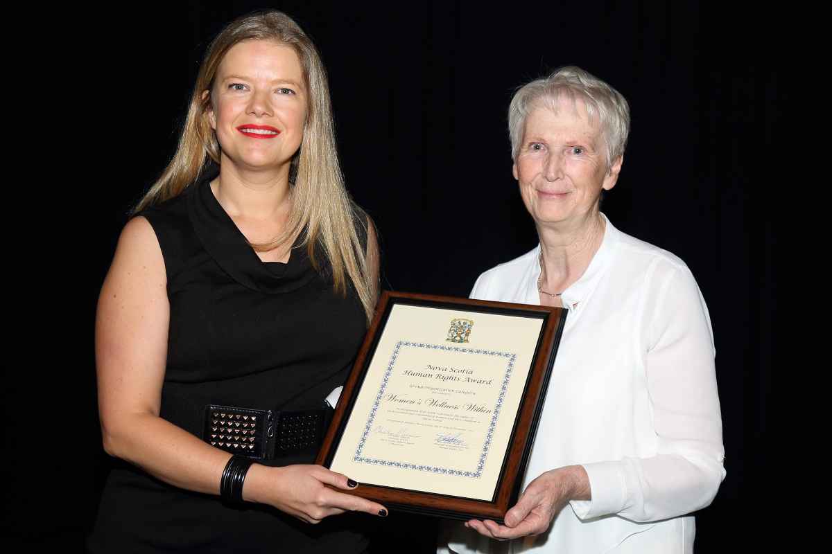 Commission Chair Eunice Harker presents award to Martha Paynter on behalf of Women's Wellness Within