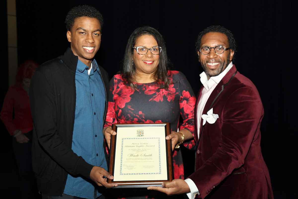 Rev. Dr. Lennett Anderson presents Wade Smith's human rights award to his family